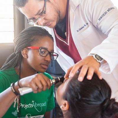 Durante brigada médica, interna realiza chequeo de salud en sus prácticas en México. Interna de medicina examina a un paciente durante una brigada médica en México.